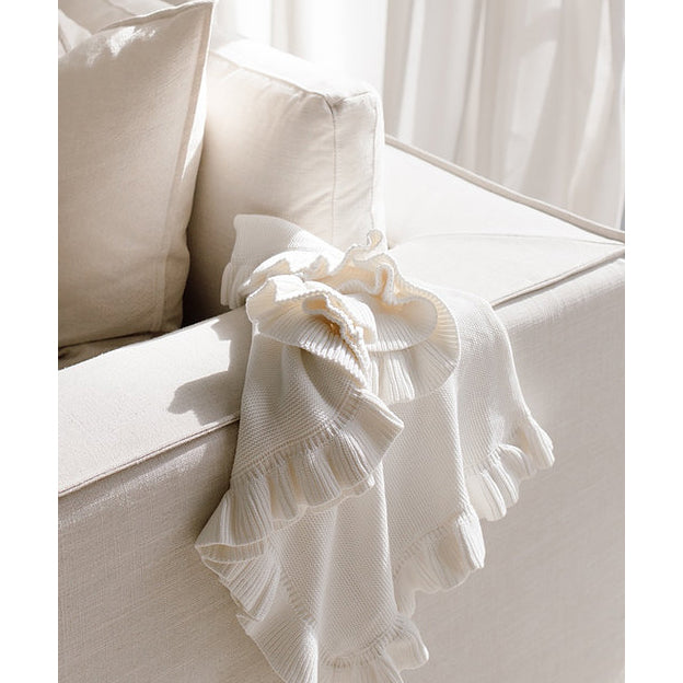 Organic Milk Frill Blanket draped over a couch